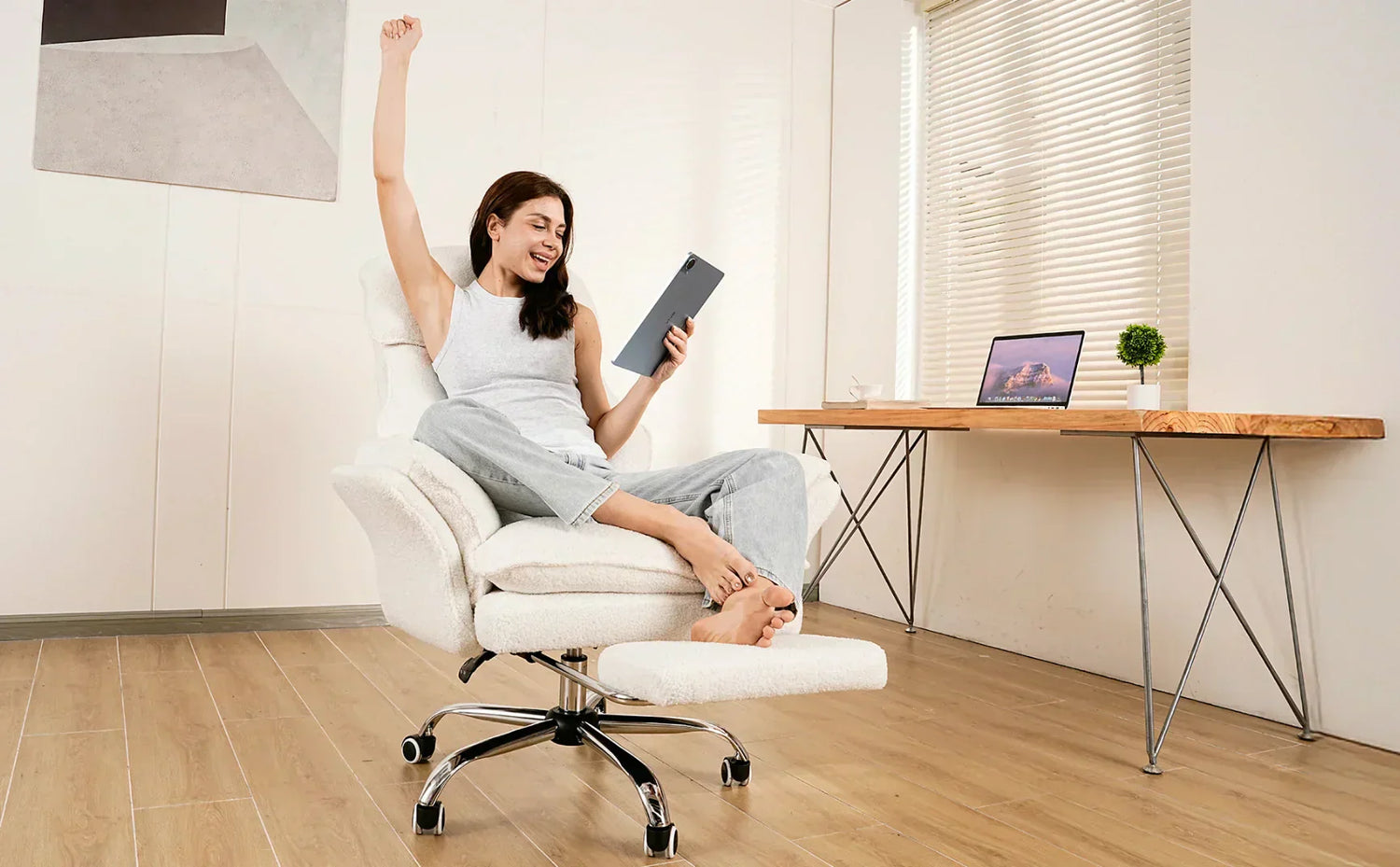 An excited woman relaxing with her feet up on the footrest of a white ergonomic computer chair in her home office.